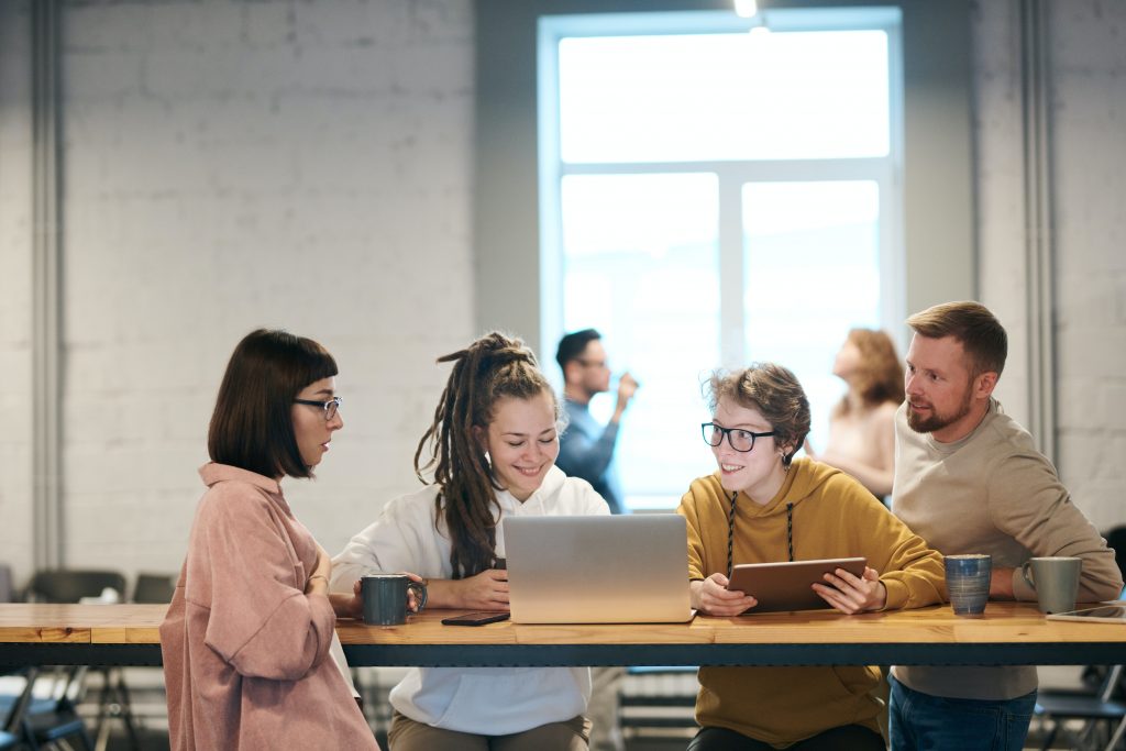 4 employees engaged in casual conversation over coffee