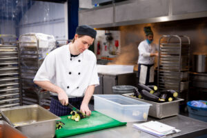 Chef chopping vegetables in a catering kitchen