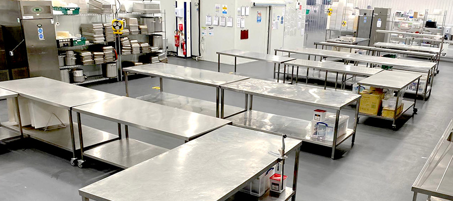 Empty tables ready to be cooked on at Fooditude's contract catering production kitchen