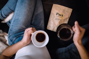 Photography of Pact coffee packaging & freshly brewed coffee, one of our sustainable suppliers for our corporate catering company.