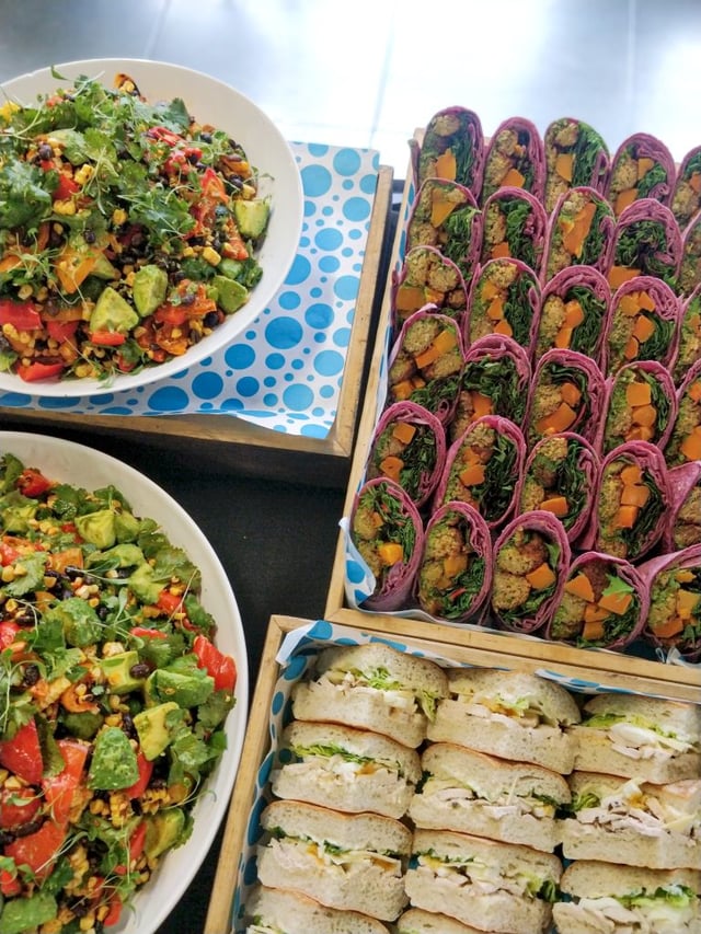 Photograph of contract caterer: Fooditude's event menu's including fresh salad, wraps and sandwiches.