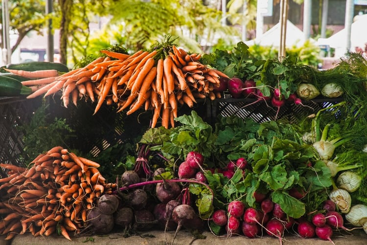 Image of local and seasonal vegetables stacked on a table ready to be cooked.