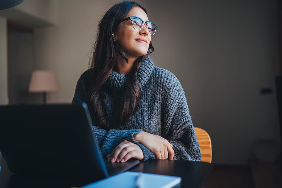 Picture of an employee sat on their desk at work.