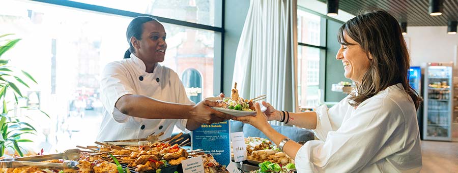 Fooditude team member serving food