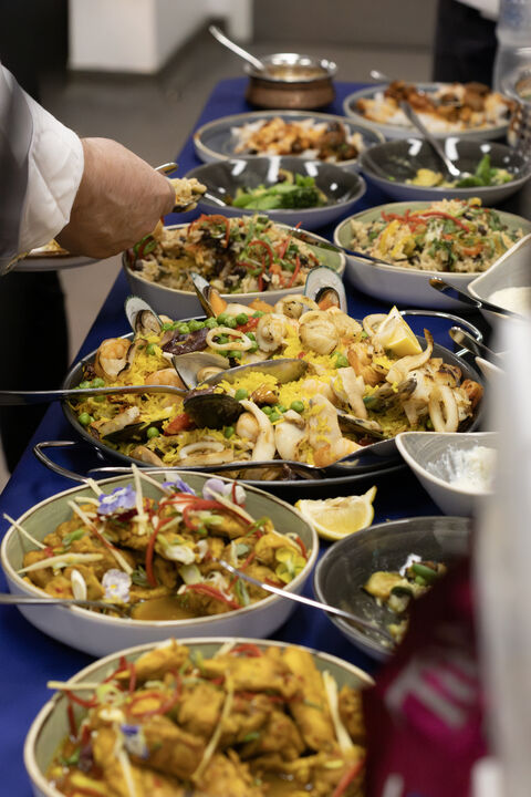 Buffet of dishes including seafood paella prepared by the Fooditude chef team